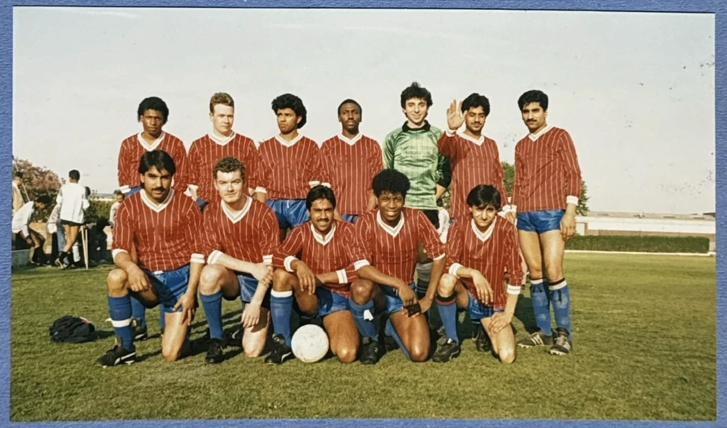 Mark Rosegreen with teammates in a red team strip, overseas tour group photograph